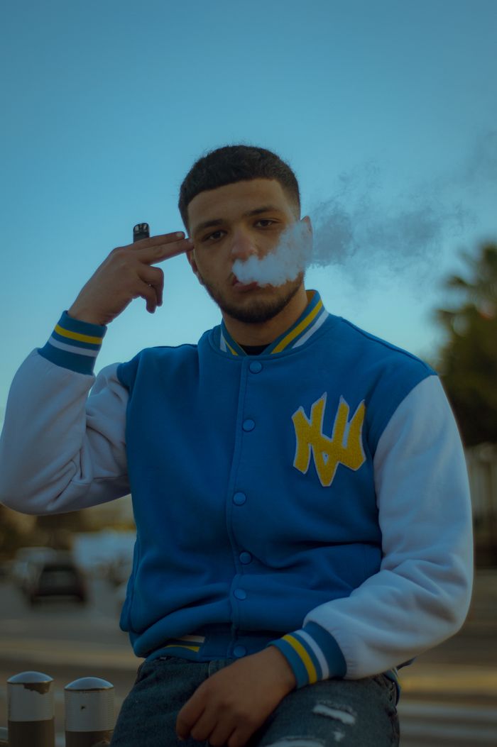 Young man with vape smoke outdoors in Casablanca, Morocco.